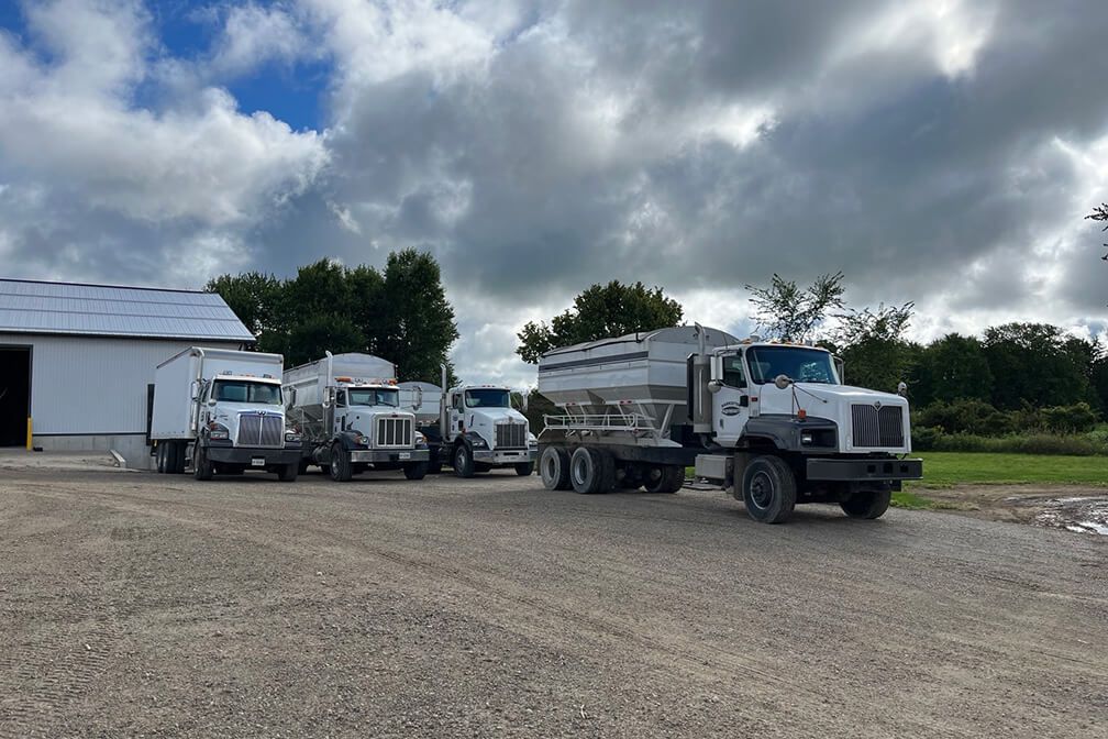Image of Harriston Agromart's delivery trucks, blue skies in the background