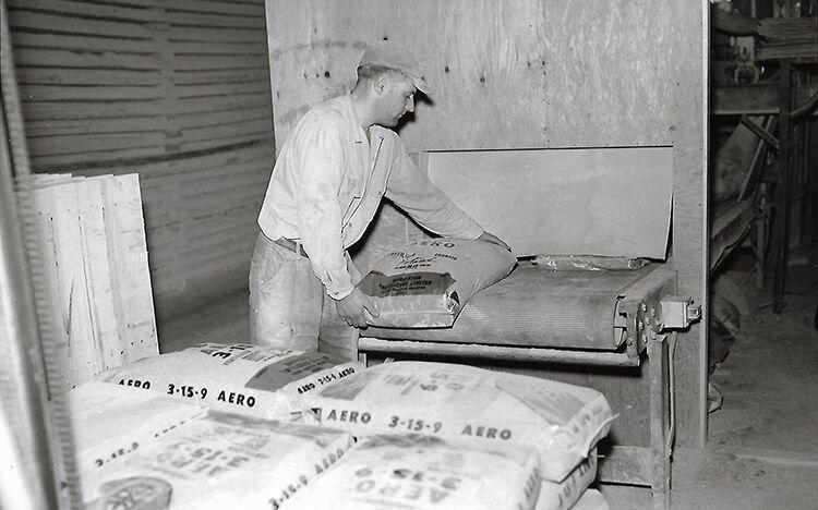Harriston Agromart employee working in facility in black and white